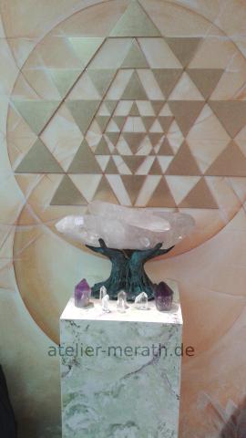 Bronzehand mit Kristall vor Sri Yantra