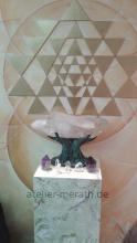 Bronzehand mit Kristall vor Sri Yantra